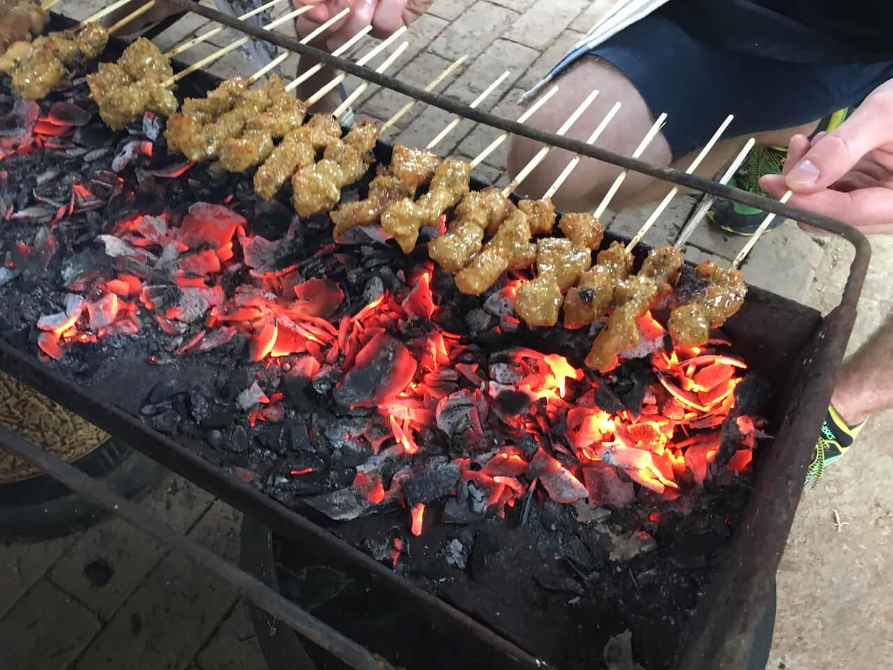 Grill coconut smoked Balinese pork satay.